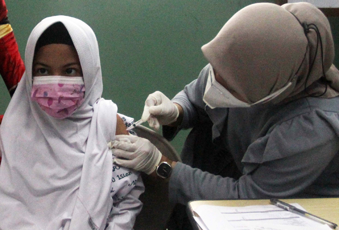 Murid Sekolah Dasar saat pelaksanaan vaksin Covid-19 dosis kedua di Sekolah Al -Azhar, BSD, Tangerang Selatan, Banten, Senin (11/01/20222). Empat ratus lima puluh murid divaksin dengan melibatkan tokoh spiderman untuk menghibur anak-anak sekaligus menghil - Image