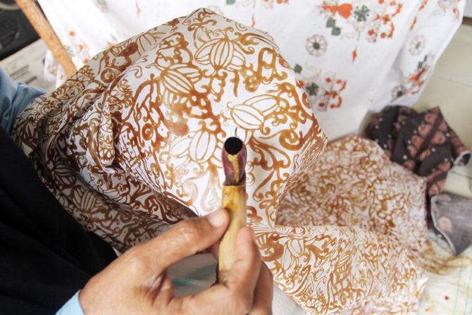 Perajin menyelesaikan pembuatan batik di sentra batik Depok Tradjumas, Depok, Jawa Barat, Jumat (26/2/2022). Produksi batik Depok kembali menggeliat setelah diberlakukannya pembelajaran tatap muka (PTM) Kota Depok karena banyak murid SD dan SMP menggunaka - Image