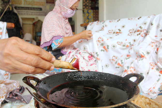 Perajin menyelesaikan pembuatan batik di sentra batik Depok Tradjumas, Depok, Jawa Barat, Jumat (26/2/2022). Produksi batik Depok kembali menggeliat setelah diberlakukannya pembelajaran tatap muka (PTM) Kota Depok karena banyak murid SD dan SMP menggunaka - Image