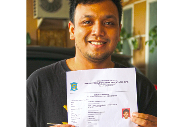 PENGGANTI KARTU: Salah seorang warga, Pramudya Bagas, menunjukkan surat keterangan pengganti e-KTP di Jalan Pucang Anom. (Frizal/Jawa Pos) - Image
