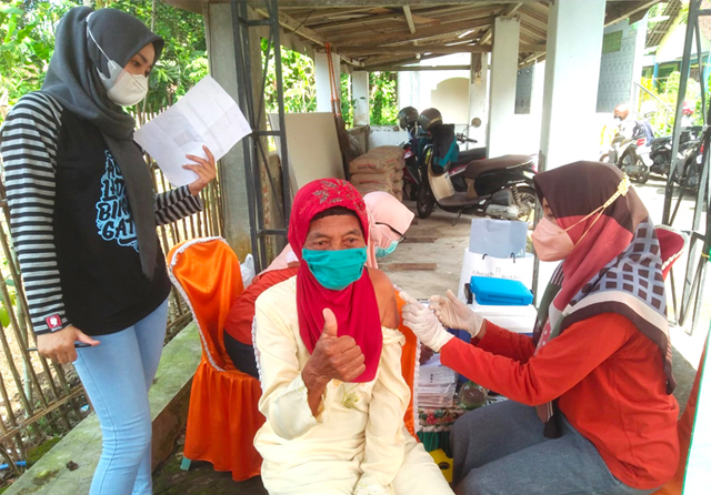 BERLANJUT: Seorang warga menjalani vaksinasi dosis kedua di Dusun Jalen Darungan, Desa Setail, Kecamtan Genteng, Banyuwangi, pada akhir pekan lalu. Hingga kini, program vaksinasi terus bergulir di seluruh wilayah di Jatim. (Jawa Pos Radar Banyuwangi) - Image