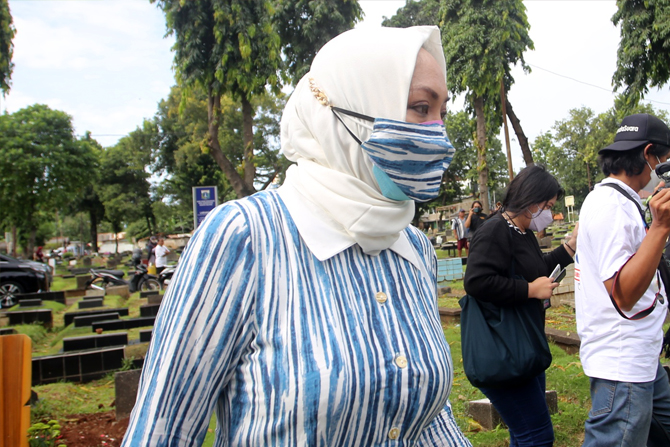 Angelina Sondakh saat berziarah ke makam suaminya, Adjie Massaid di Taman Pemakaman Umum (TPU) Jeruk Purut, Cilandak, Jakarta Selatan, Kamis (3/3/2022). Mantan anggota DPR RI Angelina Patricia Pinkan Sondakh atau Angelina Sondakh berziarah ke makam mendia - Image
