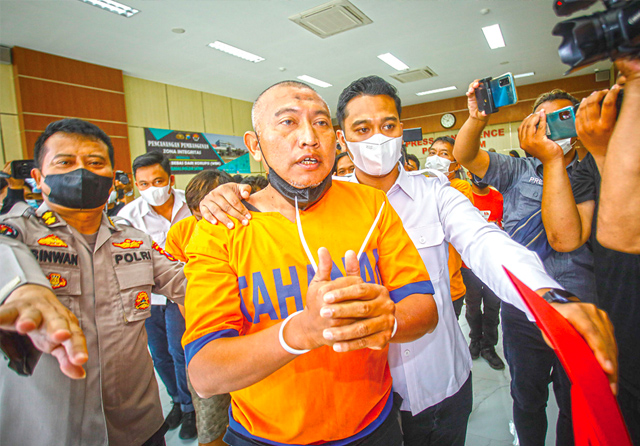 TERSANGKA UTAMA: Bambang Suryo, tersangka kasus pengaturan skor sepak bola, saat dibawa tim khusus Polda Jawa Timur setelah menghadiri jumpa pers di Kepolisian Daerah Jawa Timur di Surabaya, Rabu (16/3). (Dipta Wahyu/Jawa Pos) - Image
