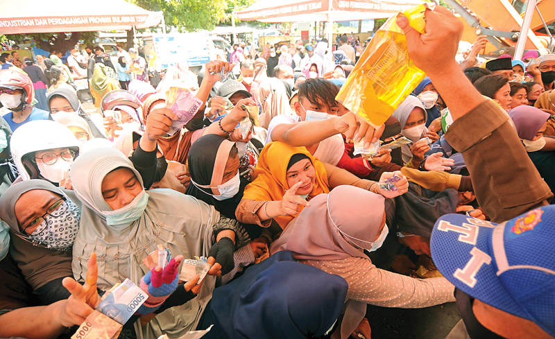 STOK TERBATAS: Warga berebut minyak goreng di pasar murah Jalan S. Parman, Besusu Tengah, Kota Palu, Sulawesi Tengah, kemarin (15/3). (MUGNIS/RADAR SULTENG) - Image