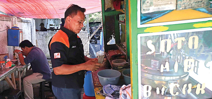 CITA RASA MAKNYUS: Pak Sabar melayani pembeli soto mi di warung kaki lima di kawasan Tebet, Jakarta. (FEDRIK TARIGAN/JAWA POS) - Image