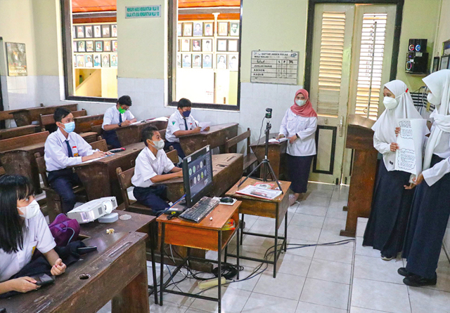 BELAJAR DI KELAS: Murid SMPN 3 Surabaya mengikuti pembelajaran tatap muka (PTM), Rabu (16/3). Pemkot Surabaya akan memberlakukan PTM 100 persen hari ini. (Frizal/Jawa Pos) - Image