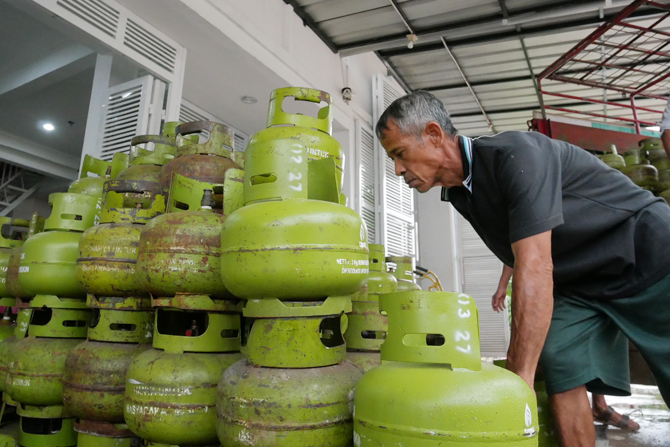 Pekerja saat menata gas elpiji 3 Kg di salah satu toko agen sembako, Jakarta, Rabu (6/4/2022). Pemerintah saat ini tengah mengkaji untuk menaikkan harga jual Liquefied Petroleum Gas(LPG) 3 kilo gram (kg) atau yang dikenal dengan gas - Image