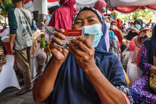 Salah seorang warga menunjukkan kartu penerima BLT miliknya. Humas Pemkot Surabaya - Image