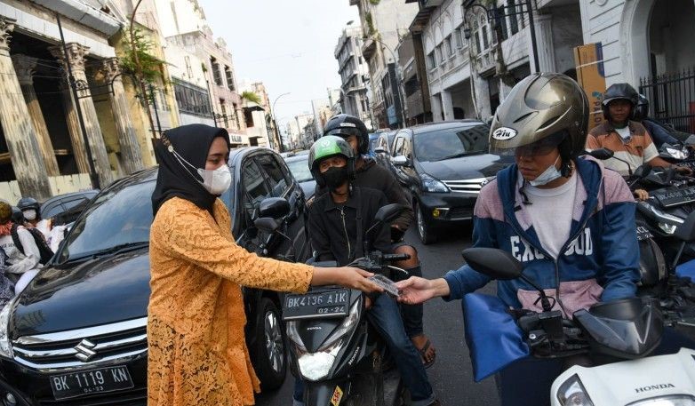 Polwan Ditlantas Polda Sumatera Utara dengan mengenakan kebaya membagikan takjil secara gratis kepada pengendara dan pejalan kaki di seputar Lapangan Merdeka, Kota Medan, Kamis (21/4/2022). (ANTARA/Nur Aprilliana Br Sitorus) - Image