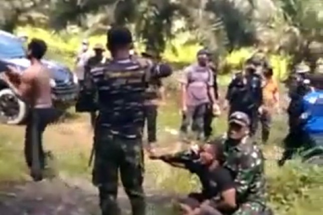 Personel Brimob Kalbar mengamankan warga yang diduga mencuri buah kelapa sawit. Istimewa/Antara - Image