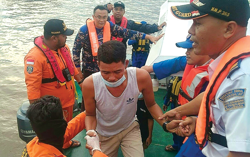 KEMBALI KE DARATAN: Tim SAR gabungan mengevakuasi seorang penumpang KMN Ladang Pertiwi 02 yang berhasil menyalamatkan diri saat kapal tersebut karam Kamis (26/5). (AFP) - Image
