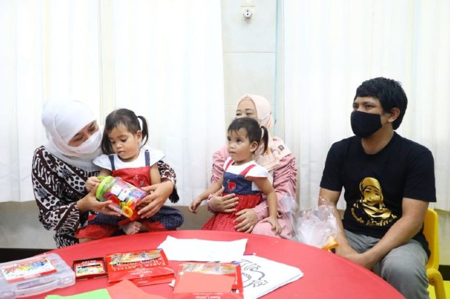 Gubernur Jatim Khofifah Indar Parawansa (kiri) menggendong balita kembar dempat yang saat ini sudah pulih, Annaya dan Innaya, didampingi orang tuanya di RSUD Soetomo Surabaya, Selasa (28/6). Biro Adpim Jatim/Antara - Image