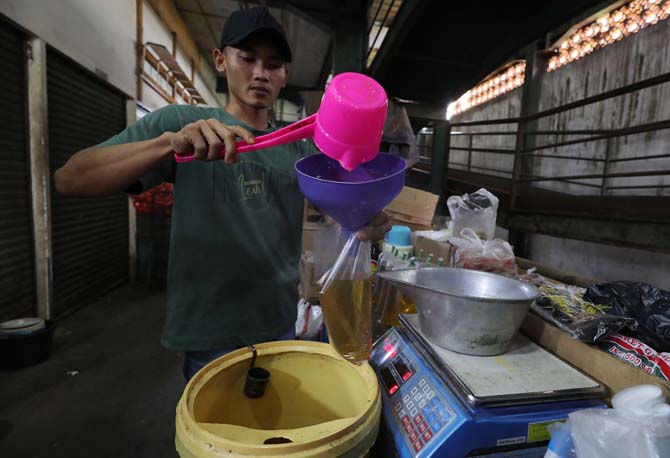 Pedagang mengemas Minyak goreng Curah yang akan di perjualbelikan di Pasar Senen, Jakarta, Senin (31/5/2022). secara resmi Kementerian Perindustrian (Kemenperin) cabut program subsidi minyak goreng curah. meski sudah tidak ada subsidi, bukan berarti subsi - Image