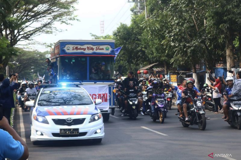 Bus rombongan tim berjuluk Singo Edan, Arema FC pada saat melintas di kawasan Jalan Soekarno Hatta, Kota Malang, Jawa Timur, Senin (18/7/2022). (ANTARA/Vicki Febrianto) - Image