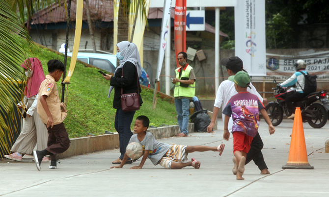 Sejumlah anak-anak bermain sepak bola di depan pelataran Taman Ismail Marzuki (TIM) Jakarta, Rabu (13/7/2022). Kurangnya lahan bermain di ibu kota menyebabkan banyak anak-anak yang menggunakan ruang terbuka untuk bermain bola kendati tidak sesuai dengan p - Image
