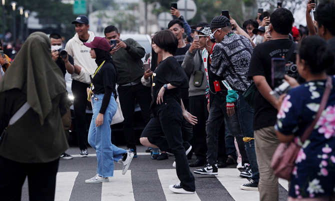 Masyarakat berkumpul saat menyaksikan fashion week di Dukuh Atas, Jakarta, Jumat (22/7/2022). Pemerintah Provinsi DKI Jakarta mengeluarkan aturan tegas dengan menerapkan jam malam di kawasan Stasiun BNI City, Dukuh Atas, Jakarta Pusat. Tempat ini sekarang - Image