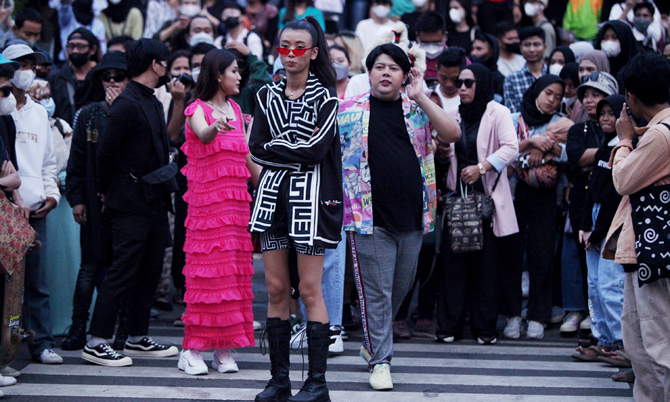 Masyarakat berkumpul saat menyaksikan fashion week di Dukuh Atas, Jakarta, Jumat (22/7/2022). Pemerintah Provinsi DKI Jakarta mengeluarkan aturan tegas dengan menerapkan jam malam di kawasan Stasiun BNI City, Dukuh Atas, Jakarta Pusat. Tempat ini sekarang - Image