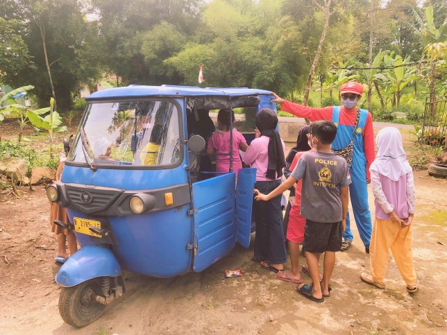 Anak-anak mengantre mengambil buku dalam bajaj. Busa Pustaka for JawaPos - Image