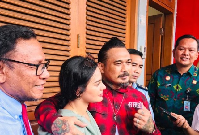 Drummer grup band Superman is Dead I Gede Ari Astina alias Jerinx (tengah), didampingi istri dan pengacara saat bebas dari Lapas Kerobokan, Badung, Bali, Selasa (2/8). Rolandus Nampu/Antara - Image
