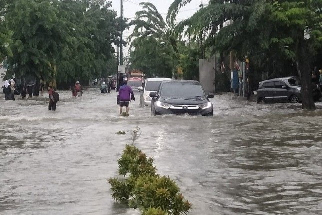 Hujan deras menyebabkan banjir setinggi 50 cm di permukiman warga dan jalur lalu lintas kendaraan di beberapa bagian wilayah Kota Medan, pada Kamis (18/8) - Image