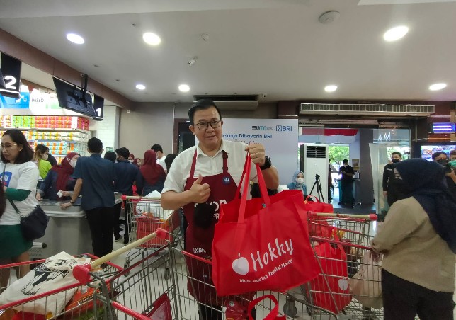 Tjahjo membawa belanjaannya paska membayar dengan BRIMo di Hokky Surabaya. Rafika Yahya/JawaPos.com - Image