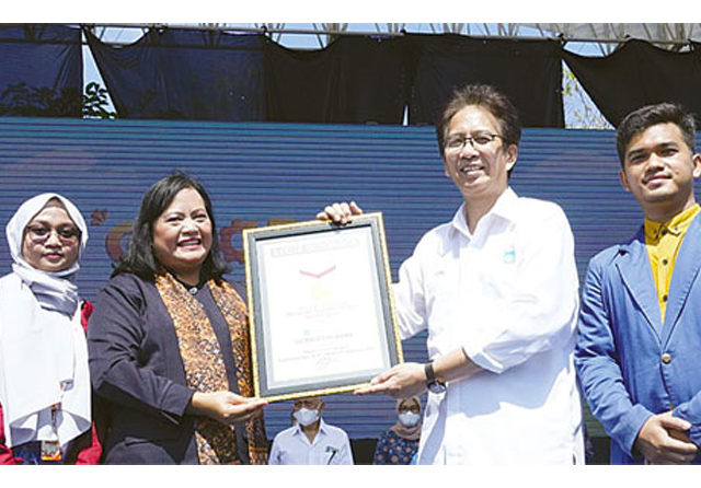 PRESTASI: Perwakilan Muri Sri Widyawati (dua dari kiri) menyerahkan plakat rekor Muri kepada Rektor ITS Prof Mochamad Ashari. Sebanyak 5.500 mahasiswa baru (maba) ITS berhasil membuat konfigurasi flash mob terbesar. (Septinda Ayu/Jawa Pos) - Image