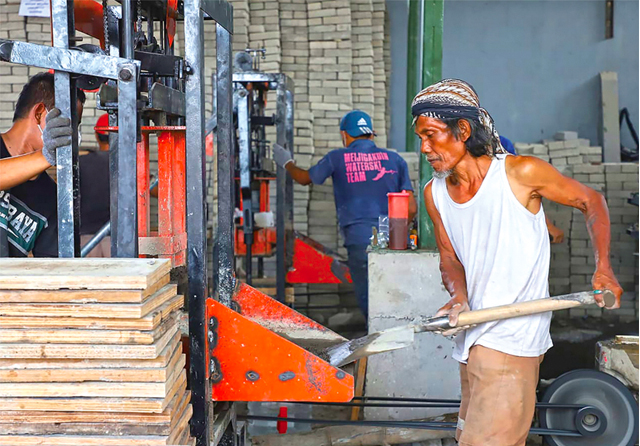 PAKAI MESIN: Pekerja membuat paving di proyek padat karya. Paving tersebut nanti dibeli Pemkot Surabaya untuk memperbaiki jalan permukiman. (Galih Adi Prasetyo/Jawa Pos) - Image