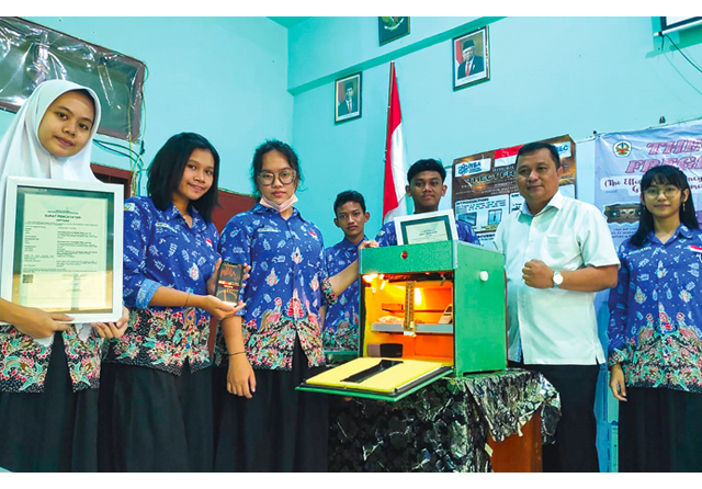 INOVATIF: Michelle Tiffany Laowo (tiga dari kiri), ketua kelompok peneliti SMA Negeri 21 Surabaya, bersama guru pendamping Budi Santoso (baju putih) memperlihatkan kubus inkubator sebagai sarana mempercepat fermentasi tempe dengan menggunakan genre musik - Image