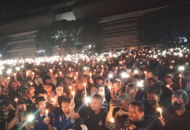 Ribuan suporter berbagai klub sepak bola se-Pulau Jawa menyalakan lilin dan cahaya gawai sebagai simbol perdamaian di halaman parkir Stadion Mandala Krida, Kota Jogjakarta, Selasa (4/10) malam. Luqman Hakim/Antara - Image