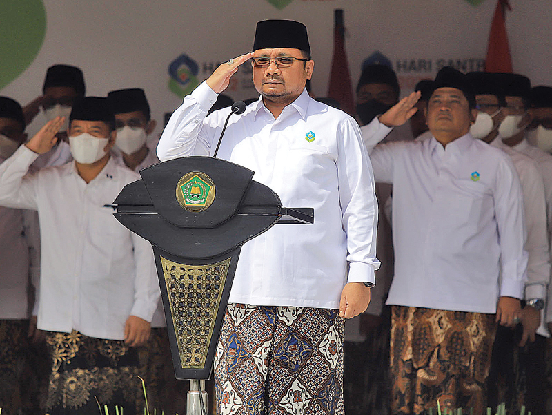 BUSANA KHAS SANTRI: Menteri Agama Yaqut Cholil Qoumas memimpin upacara peringatan Hari Santri 2022 di halaman Kementerian Agama, Jakarta, Minggu (22/10). (HANUNG HAMBARA/JAWA POS) - Image