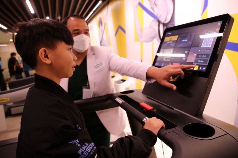 tlet esport dari tim EVOS Divine Rasyah Rasyid (kanan) melakukan mencoba treadmill didampingi oleh dr. Antonius Andi Kurniawan, Sp.KO (kiri) dalam kegiatan Kinetic Activity Piala Presiden Esports 2022 di Sport Medicine, Injury & Recovery Center (SMIRC) RS - Image