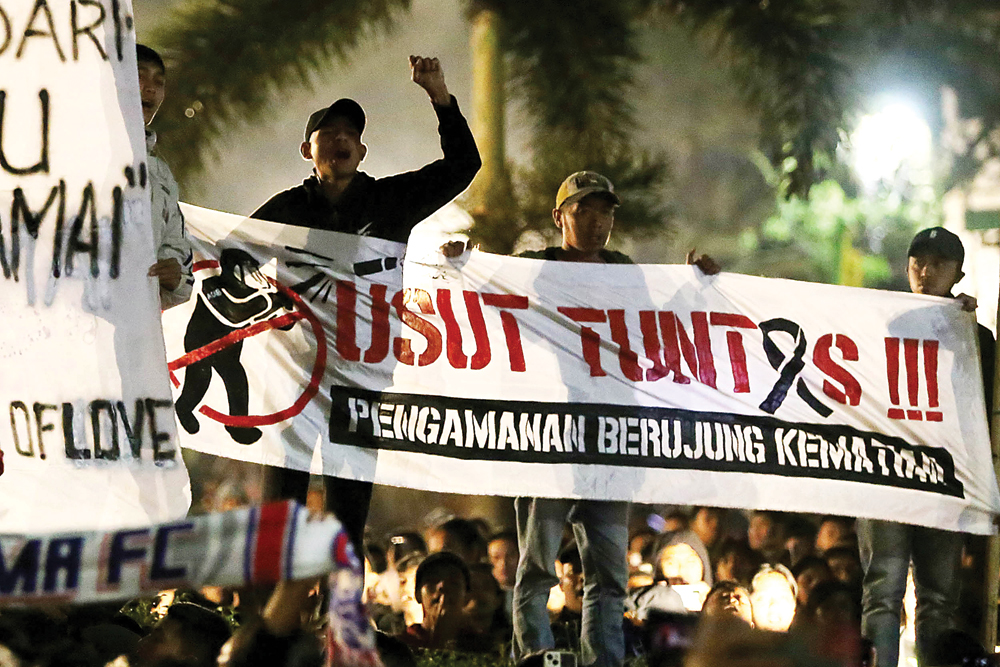 SATU RASA: Ratusan suporter Aremania menabur bunga di Balai Kota Malang, Jalan Tugu (5/10). Doa bersama tersebut sebagai bentuk belasungkawa terhadap nasib ratusan suporter yang meninggal di Stadion Kanjuruhan. (ROBERTUS RISKY/JAWA POS) - Image