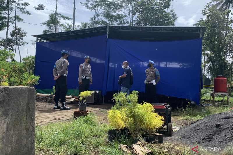 Petugas kepolisian berjaga di depan lokasi pelaksanaan autopsi di Tempat Pemakaman Umum Dusun Patuk, Desa Sukolilo, Kecamatan Wajak, Kabupaten Malang, Jawa Timur, Sabtu (5/11/2022). (ANTARA/Vicki Febrianto) - Image
