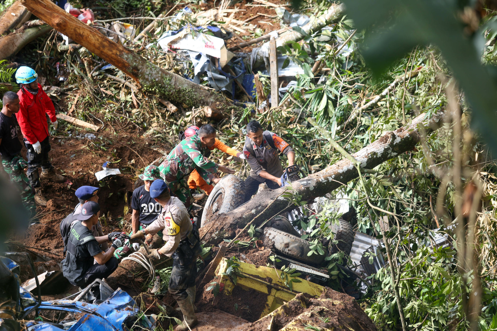 Petugas gabungan saat melakukan pencarian korban yang tertimbun longsor akibat gempa di Jalan Raya Puncak - Cianjur, Jawa Barat, Selasa (22/11/2022).Longsor yang terjadi akibat gempa tersebut menimbun sejumlah kendaraan dan korban jiwa yang masih dilakuka - Image