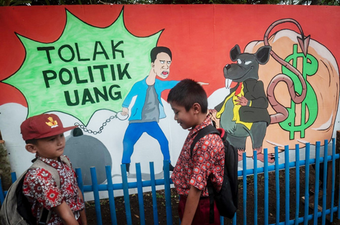 Dua siswa melintas di mural kampung demokrasi di Cileles, Lebak, Banten, Rabu (9/11/2022). Pencanangan Kampung Demokrasi tersebut dalam rangka menggelar sosialisasi serta edukasi pendidikan politik bagi masyarakat guna mensukseskan Pemilu dan Pilkada 2024 - Image