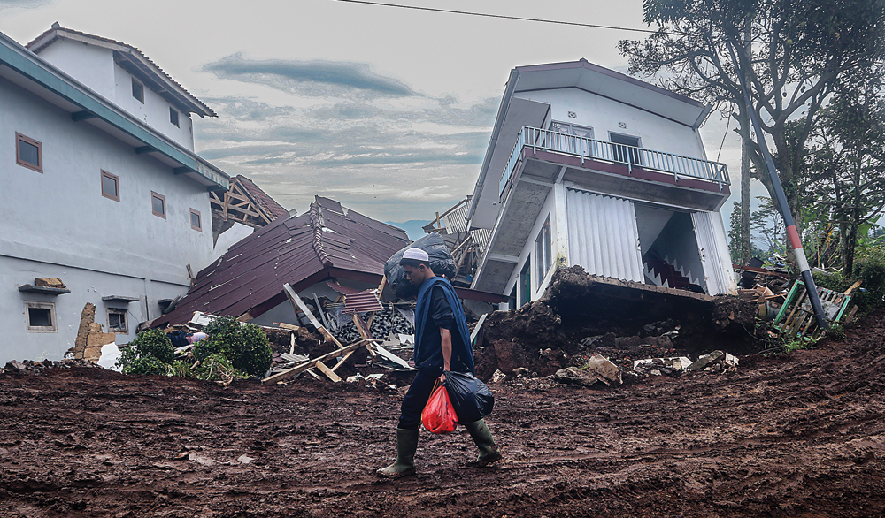 SEADANYA: Warga terdampak gempa membawa barang di Desa Sarampad, Cugenang, Cianjur, Jawa Barat, kemarin (26/11). (SALMAN TOYIBI/JAWA POS) - Image