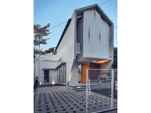 AGAR LEBIH AWET: Setiap lekukan pada fasad memiliki lubang sehingga cahaya matahari langsung menembus ke dalam rumah. Fasad kalsiboard tersebut dilapisi coating waterproof khusus outdoor supaya daya tahan lebih lama. (Dony Hendro Wibowo untuk Jawa Pos) - Image