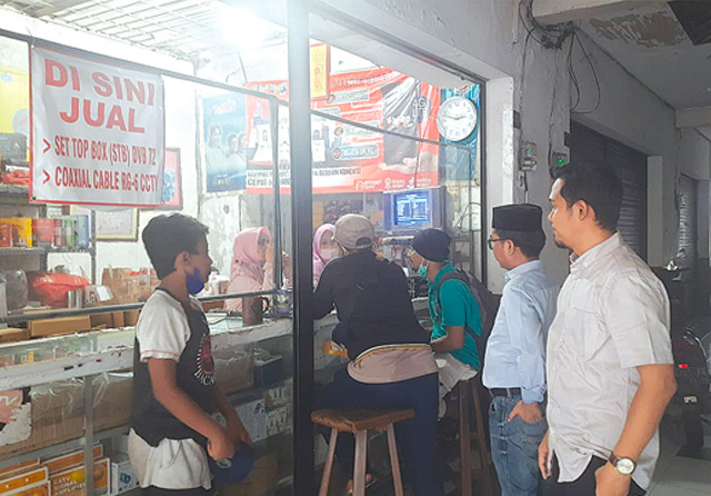 KELILING: Tim KPI dan KPID Jatim memantau ketersediaan stok dan harga STB di sejumlah toko elektronik di Pasar Genteng, Surabaya, Selasa (20/12). (Edi Susilo/Jawa Pos) - Image