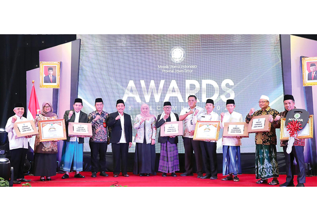 PERTAMA DI INDONESIA: Ketua MUI Jatim KH Mutawakkil Alallah (lima dari kiri) dan Gubernur Khofifah Indar Parawansa bersama pimpinan MUI kabupaten/kota peraih penghargaan dalam MUI Jatim Awards di Surabaya kemarin (28/12). Kegiatan itu disebut merupakan ya - Image
