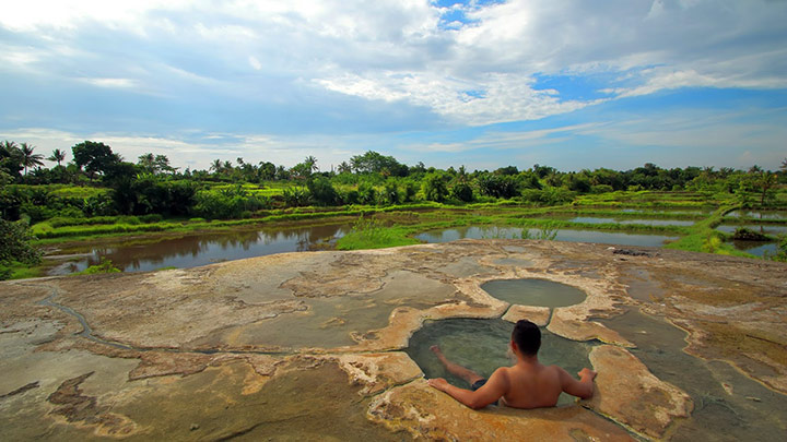 Orang sedang berendam di air panas Gunung Peyek.