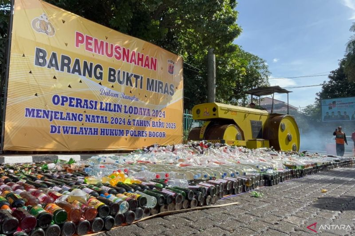 Alat berat menggilas ribuan botol miras ilegal di Lapangan Tegar Beriman, Cibinong, Kabupaten Bogor, Jumat (20/12/2024). (ANTARA/M Fikri Setiawan)