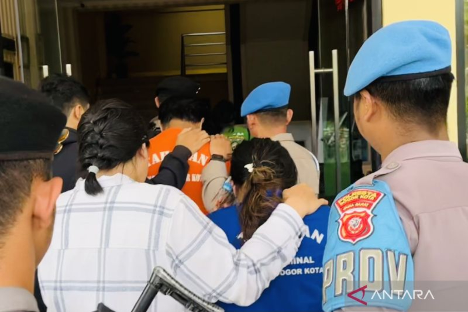 Dua tersangka TPPO yang memberangkatkan PMI ilegal digiring di Mako Polresta Bogor Kota. (ANTARA/Shabrina Zakaria)