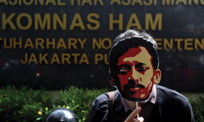 Orang mengenakan topeng Munir di depan gedung Komnas HAM. (pinterest.com)