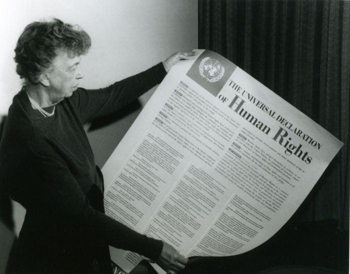 Seorang wanita memegang kertas bertuliskan Universal Declaration of Human Rights (UDHR). (pinterest.com)