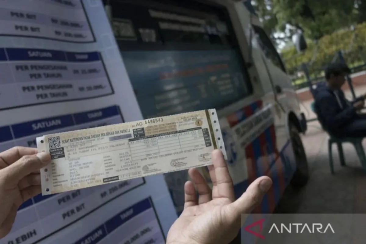 Warga menunjukkan STNK yang baru diperpanjang di Samsat Keliling. (Dok. ANTARA FOTO/Rosa Panggabean/foc/aa)