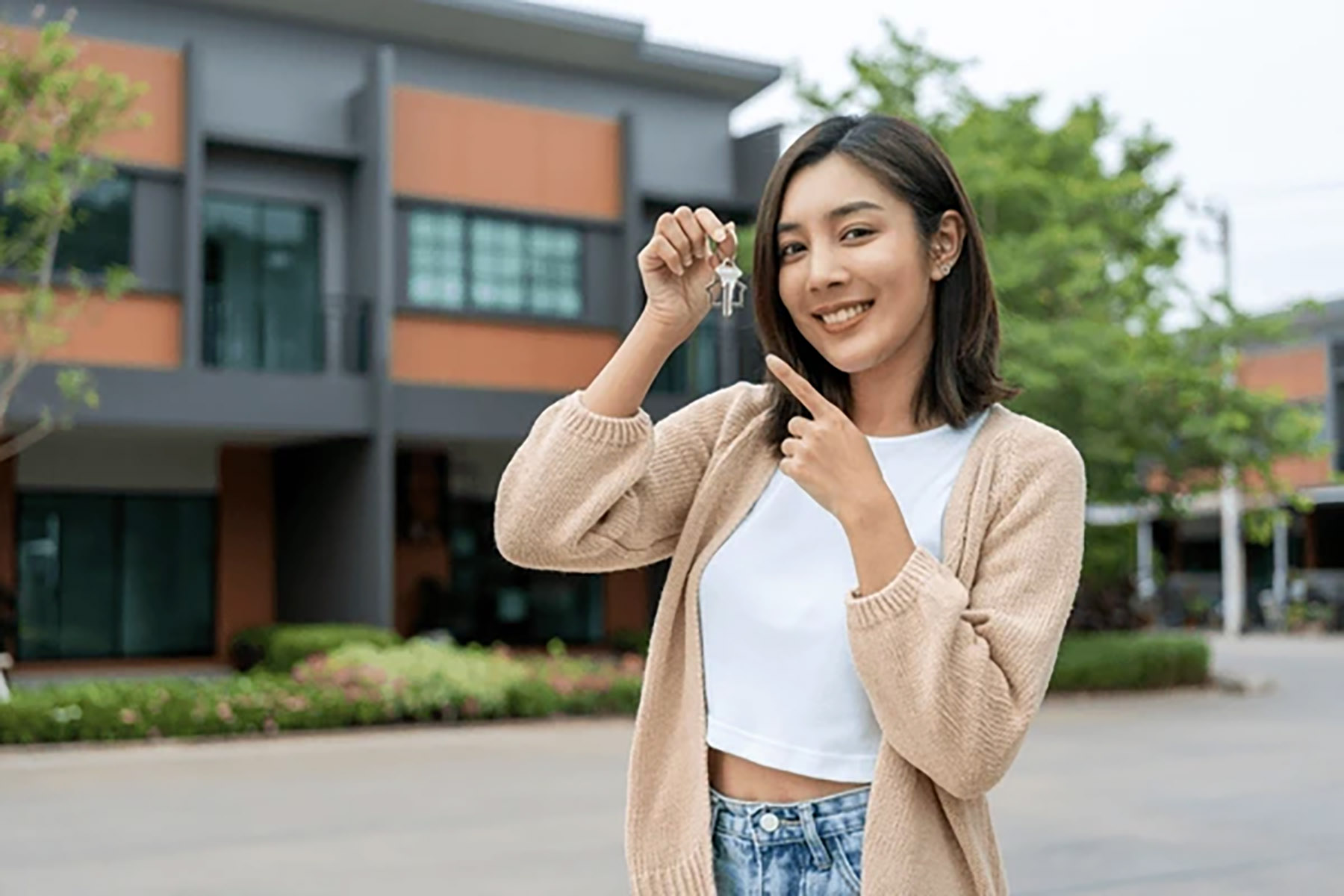Ilustrasi seorang perempuan menunjukkan kunci rumah barunya. (Dok. Shutterstock)