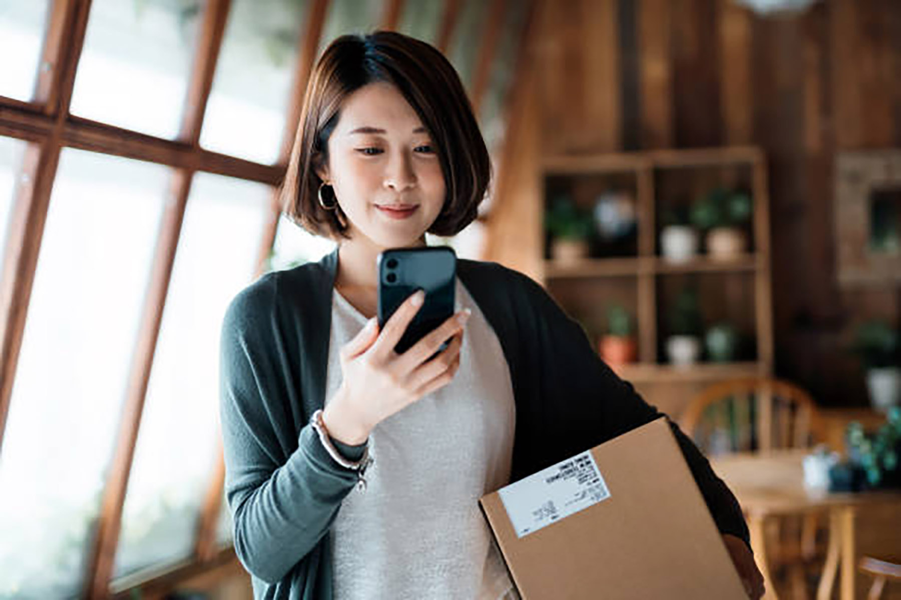 Ilustrasi seorang perempuan sedang memegang ponselnya. (Dok. iStock/AsianVision/GettyImages)