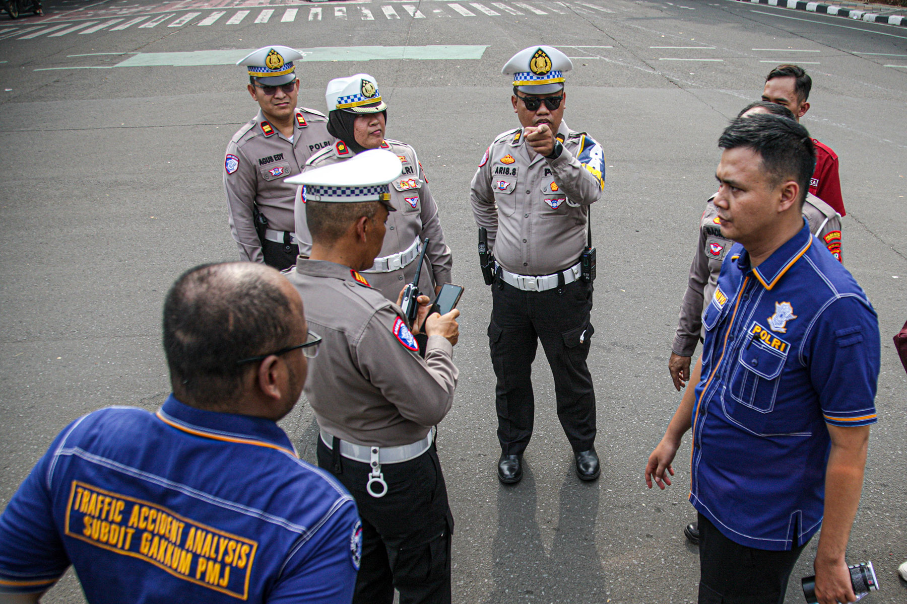 Petugas Kepolisian bersama Traffict Accident Analysis Subdit Gakum PMJ melakukan olah tempat kejadian perkara (TKP) kecelakaan truk di Tugu Adipura, Kota Tangerang, Jumat (01/11/2024).