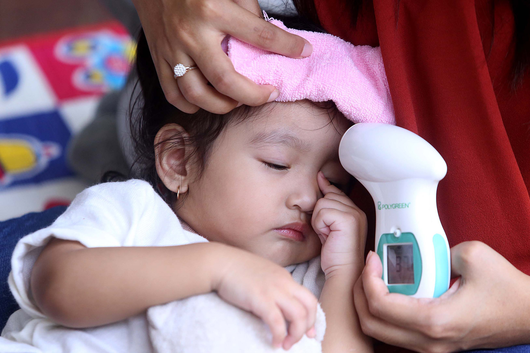 Maria Elisea, mengecek suhu badan anaknya, Pia Mikayla Alesha saat melakukan penanganan pertaman untuk anak di Kawasan Darmo Permai (24/4).