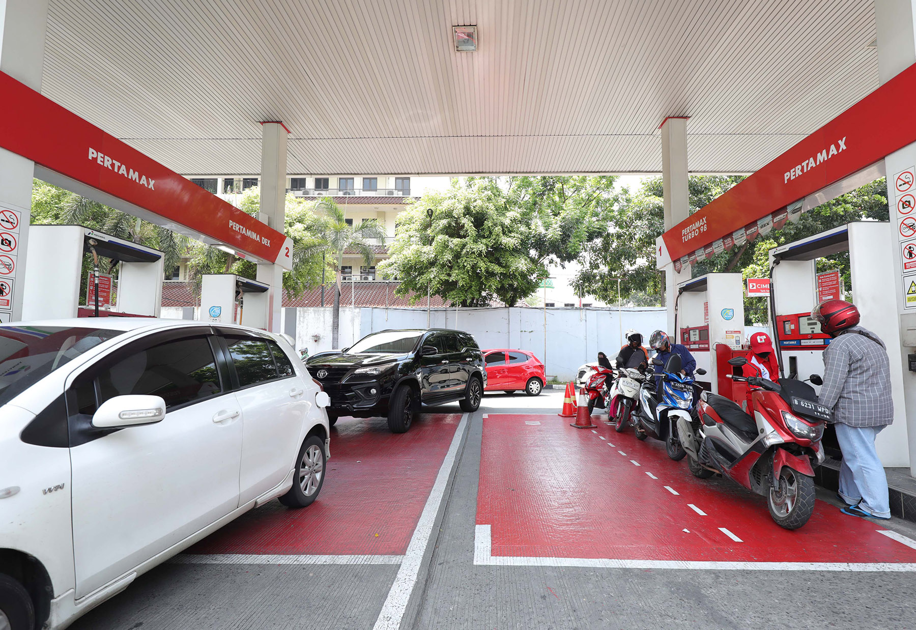 Pengendara sepeda motor dan mobil mengisi BBM di salah satu SPBU kawasan Kramat, Jakarta, Selasa (1/10/2024). PT Pertamina (Persero) melakukan penyesuaian harga bahan bakar minyak (BBM) nonsubsidi jenis Pertamax dari Rp12.950 per liter menjadi Rp12.100 pe